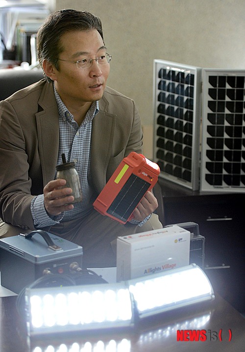Presidente Kyung Eui Yoo describe la diferencia entre las lámparas de kerosene y las lámparas de energía solar. Crédito: NewsIs.