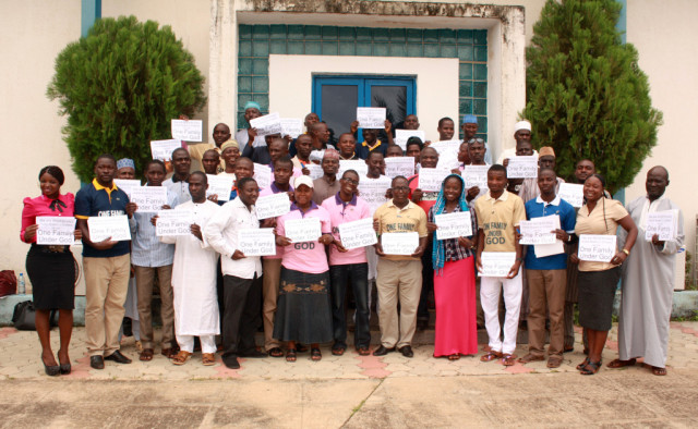 El Segundo Retiro Interconfesional de Líderes Jóvenes en el Estado de Kaduna. Los participantes sostienen las pancartas que dicen: "Seamos Musulmanes o Cristianos, somos Una Familia Bajo Dios."